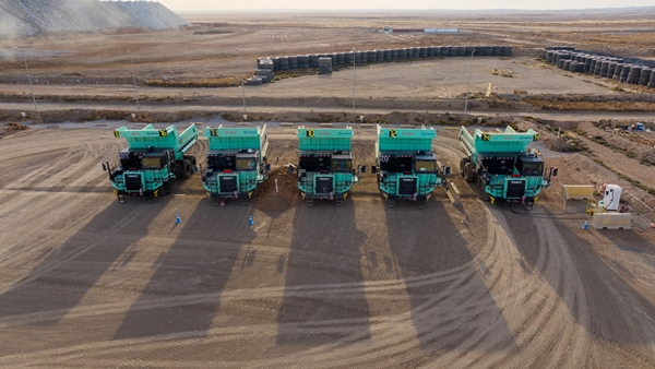 Five electric haul mining trucks lined up in a mining site in Oyu Tolgoi, Mongolia. 
