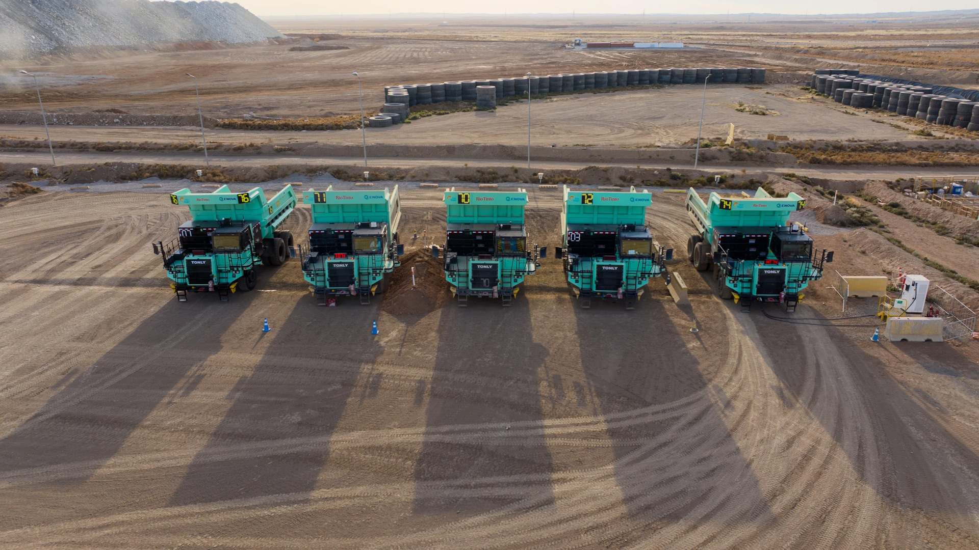 Five electric haul mining trucks lined up in a mining site in Oyu Tolgoi, Mongolia. 