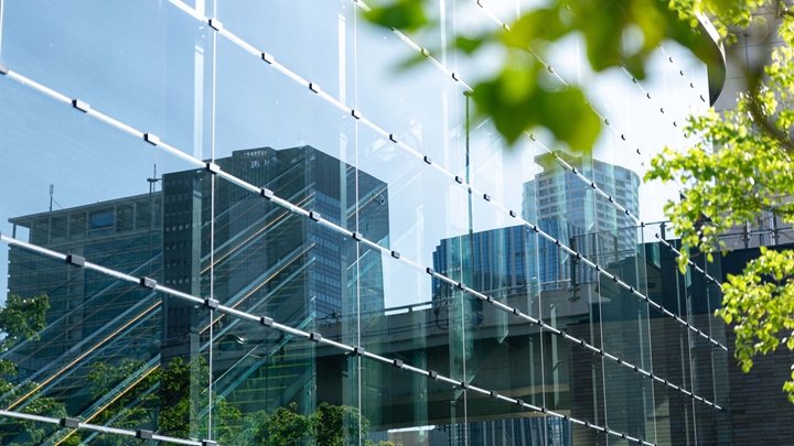 Image of an office building with reflection of other buildings on a sunny day
