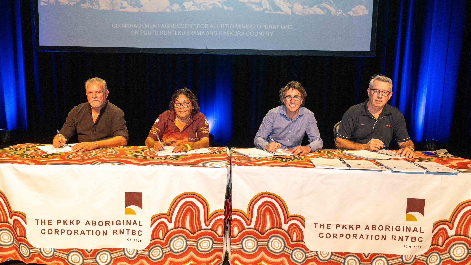 Pinikura Traditional Owner and Chairperson of PKKP Aboriginal Corporation, Terry Drage, Puutu Kunti Kurrama Traditional Owner and Director, Sandra Hayes together with Rio Tinto Iron Ore Chief Executive, Simon Trott, and Rio Tinto Iron Ore General Manager, Tim Eckersley, signing the new Co-Management Agreement in Karratha, 22 May 2025. 