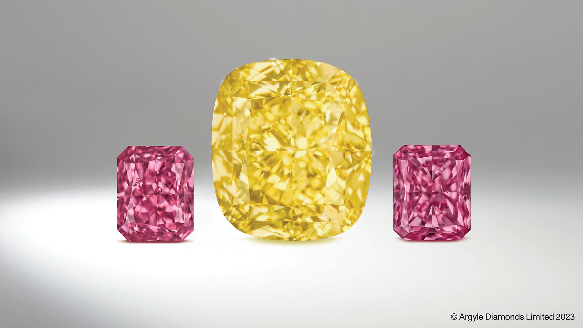 2 GIA Fancy Vivid Purplish Pink Radiants from the Argyle Diamond Mine, and 1 Fancy Intense Yellow Modified Cushion from the Diavik Diamond Mine. The carefully curated set is 3.83 carats in total