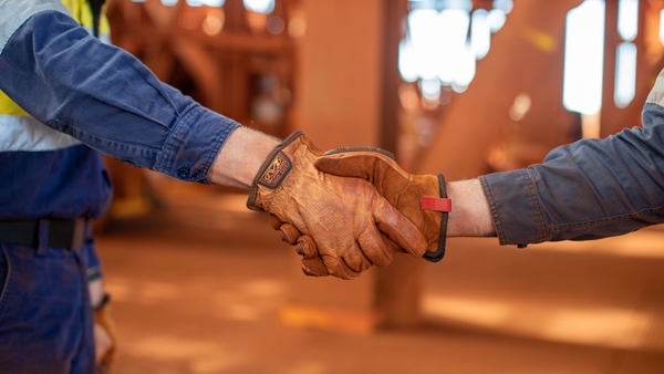 Two people shaking hands and reflecting partnership