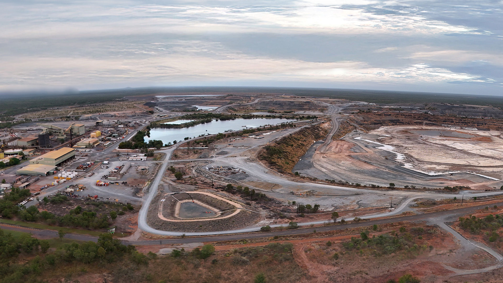 Aerial view of ERA site showing mining pit, roads, forest, lake, vehicles, offices and machineries