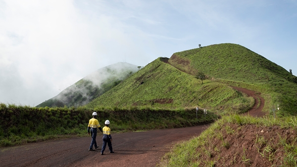 Two employees walking towards a hill