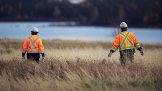 Environment employees walking on tailings
