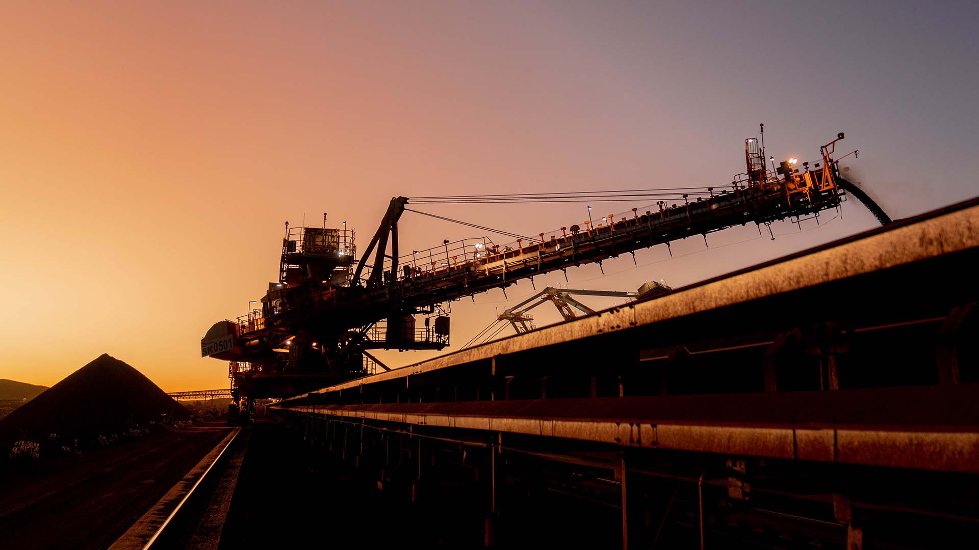 Gudai-Darri fines stacker working as the sun sets over Banjima country in the Pilbara, WA